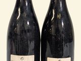 two bottles of wine sitting next to each other on a table