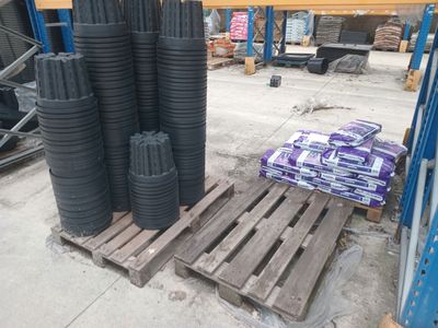 many stacks of black plastic cups on a pallet