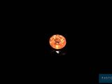 une lune orange dans le ciel sombre, sur fond noir