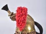 a helmet with a red feather on top of it