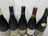 six bottles of wine are lined up in a row on a table
