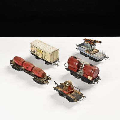 quatre petits trains miniatures posés sur une surface blanche