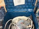 une boîte à outils bleue contenant des outils, posée par terre