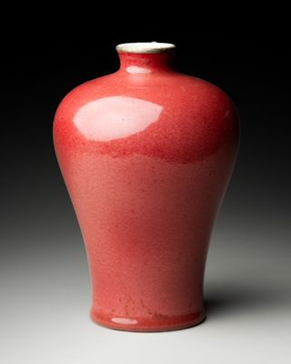 a red vase that is sitting on a table