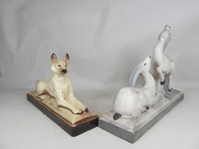 two figurines of a dog and a cat sitting on a base