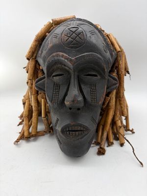 an image of a wooden mask with dreadlocks on a white background