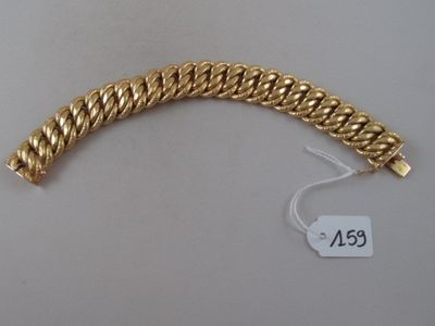 a close up of a gold bracelet on a white surface