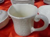 many plates and cups on a table with a red table cloth