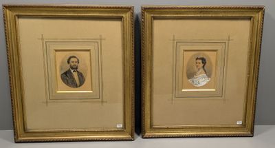 deux portraits encadrés d'hommes en costume et cravate posés sur une table
