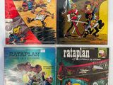 Quatre bandes dessinées sont alignées sur une surface blanche