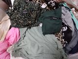a pile of clothes sitting on top of a bed