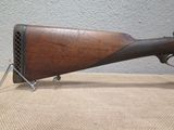 an old wooden rifle on a table with a metal stand