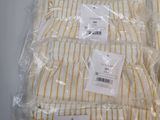 three pairs of yellow and white striped pants sitting on top of a table