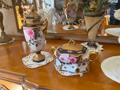 two vases on a table with a mirror in the background