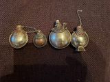 trois cuillères anciennes en argent sont posées sur un tissu marron