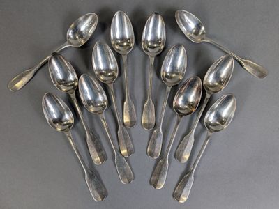 six silver spoons are arranged in a circle on a gray surface