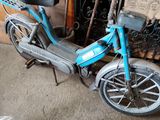a blue scooter that is parked in a garage