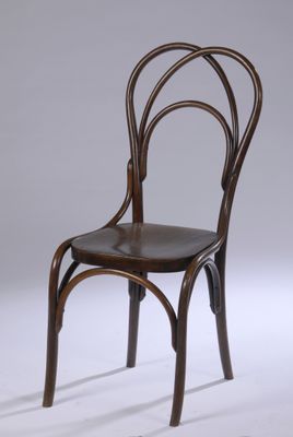 une chaise en bois avec un dossier courbé et une assise en cuir