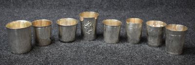 six vases en argent sont alignés sur une surface noire