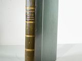an old book sitting on top of a table next to a white wall