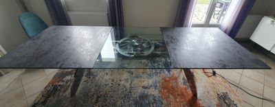 a glass table with a bowl on it in the middle of a room