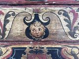 a close up of a wooden box with a face on it