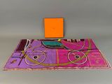 an orange box sitting on top of a table next to a purple and pink table cloth