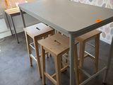 une petite table avec deux tabourets devant une fenêtre