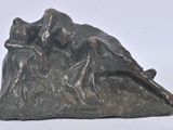 une statue représentant un homme et une femme assis au sommet d'une montagne