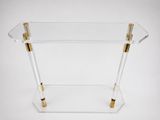 a clear acrylic table with gold handles