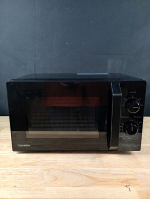 un four grille-pain noir posé sur une table en bois