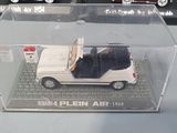 three different model cars in a display case on a table