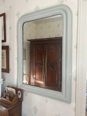 un miroir accroché au mur au-dessus d'une commode dans une pièce