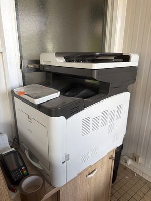 a printer sitting on top of a cabinet in a room