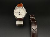 La montre est blanche et marron, avec un bracelet en cuir marron.