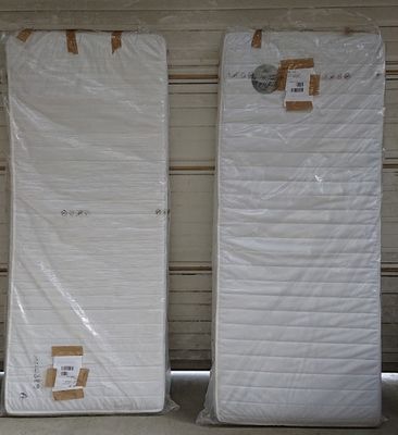 trois matelas emballés dans du plastique