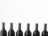 six bottles of wine are lined up in a row on a table
