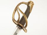 une vieille épée avec un manche en or sur fond blanc