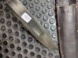 a knife that is laying on the floor next to a knife sheath