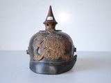 an old bell with a bird on it sitting on top of a table
