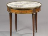 une table ronde au plateau en marbre, avec des pieds en bois