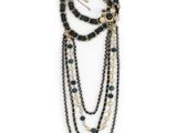a close up of a necklace with black beads and pearls