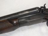 an old gun is laying on a white surface with a wooden handle