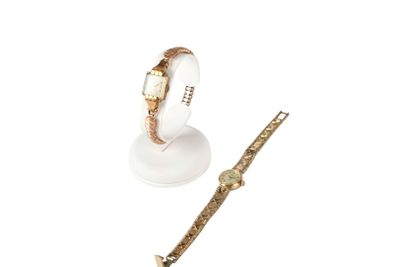 a close up of a watch and a bracelet on a white surface