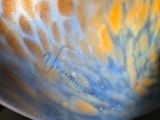 a close up of a glass bowl with a yellow and blue design
