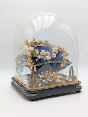 une cloche en verre contenant un coussin bleu