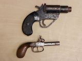 two old guns that are on a wooden table