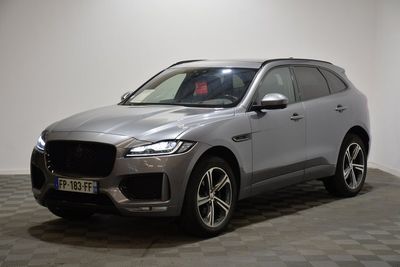 un SUV Jaguar argenté garé dans un showroom