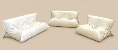 trois poufs blancs empilés les uns sur les autres sur une surface beige
