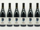 six bouteilles de vin sont alignées sur une surface blanche